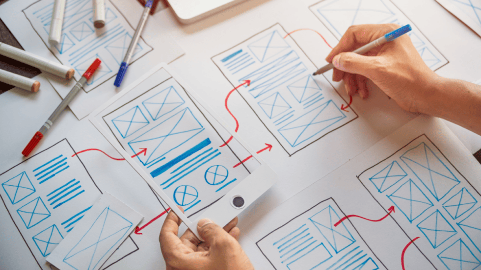 person sketching wireframes for mobile friendly manufacturing website