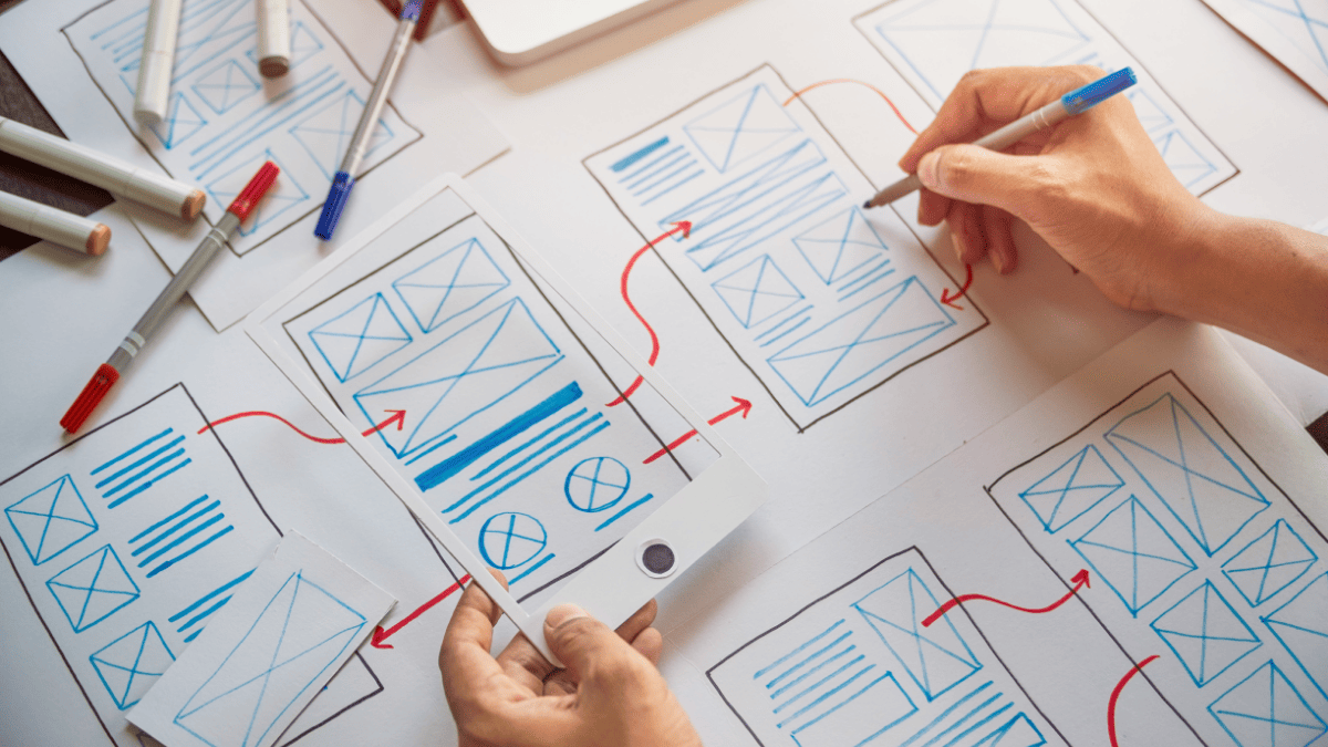 person sketching wireframes for mobile friendly manufacturing website